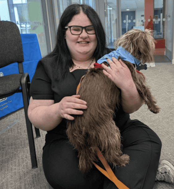 Finley Murray holding a therapet dog